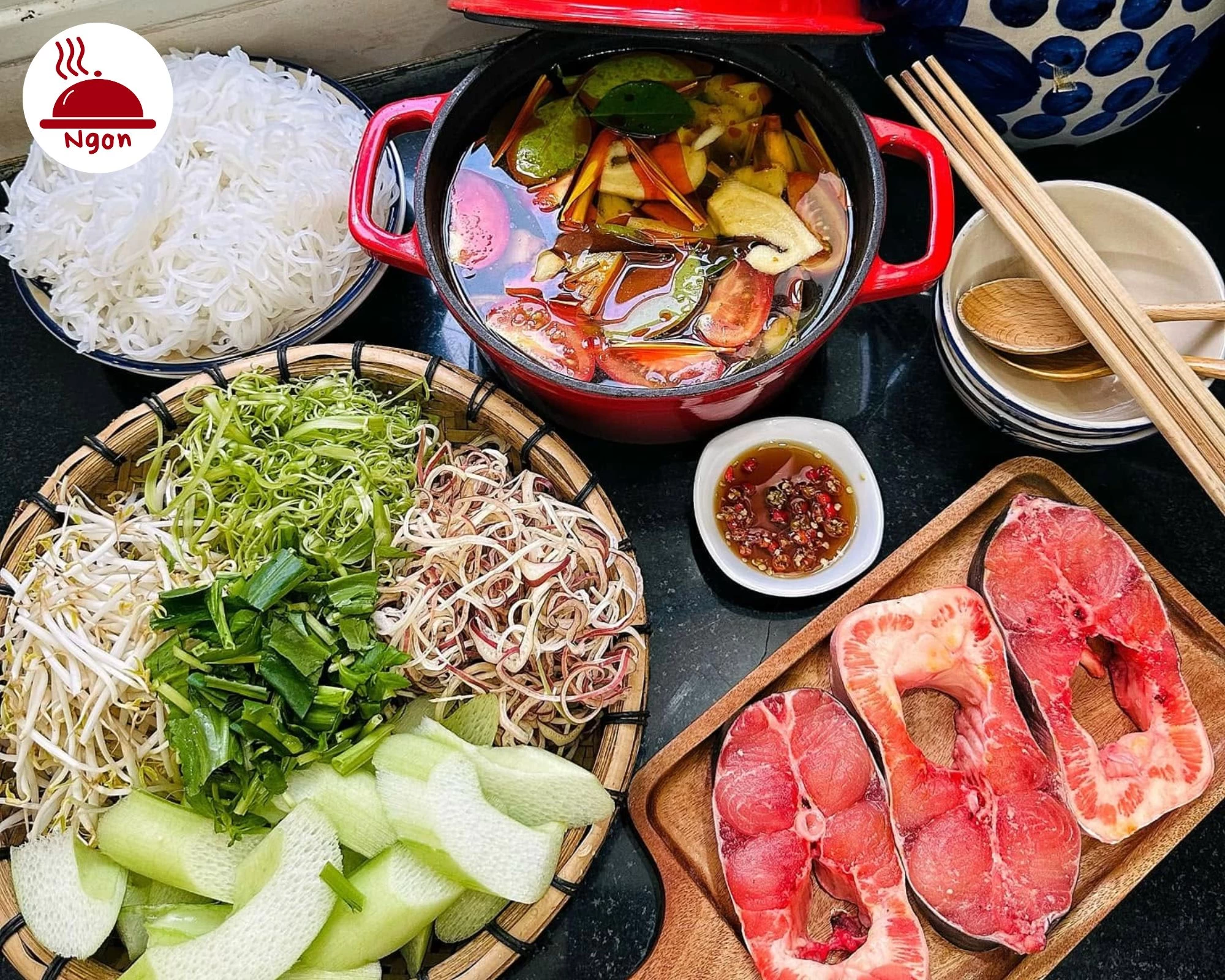 Bàn tiệc chuẩn bị nấu lẩu Thái hải sản chua cay chuẩn vị gồm nồi nước dùng cá tươi bún và rổ rau nhúng đa dạng
