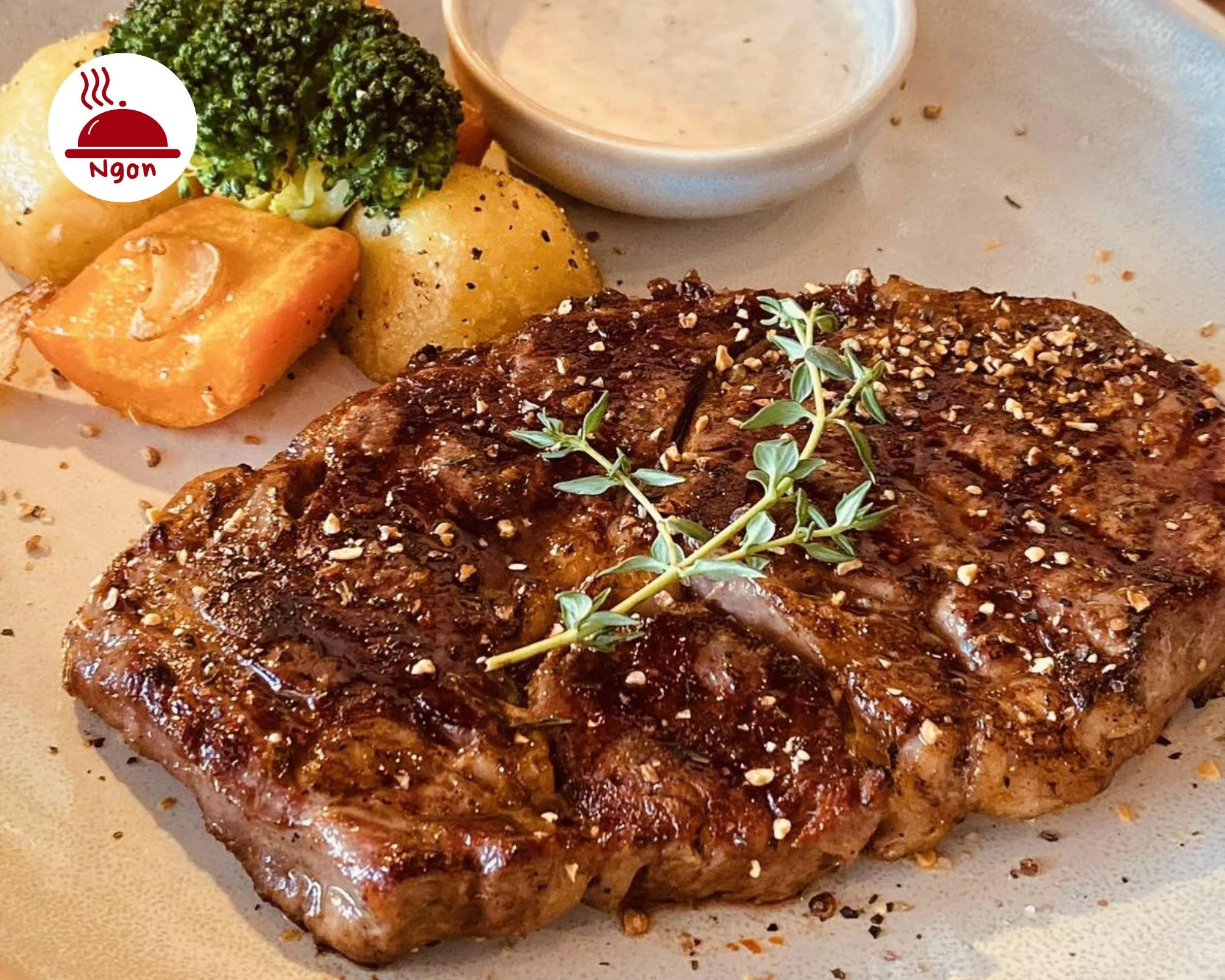 Miếng beefsteak ở Nossa Steakhouse & Italian Cuisine được nấu chín đẹp mắt được ăn kèm với khoai tây và súp lơ