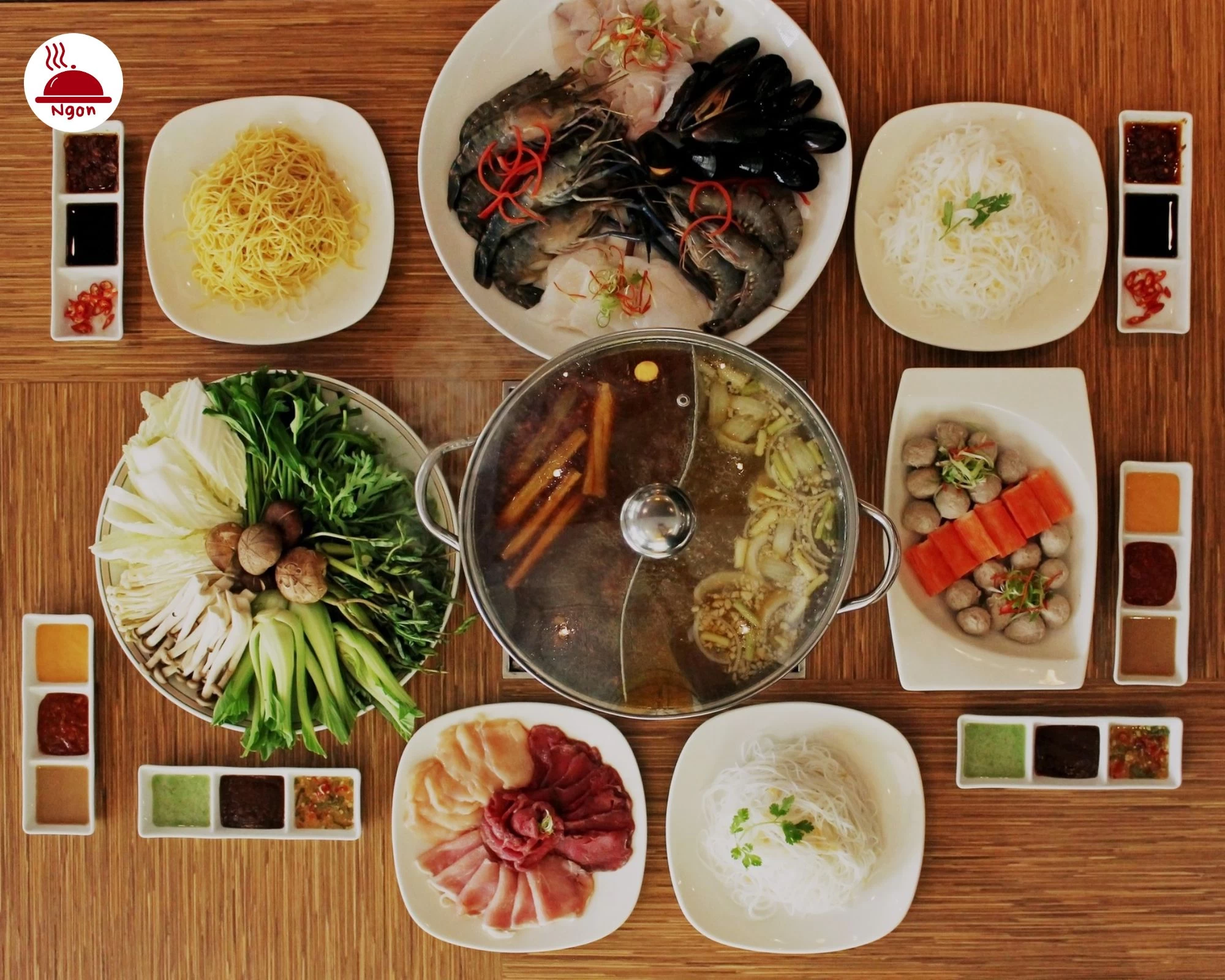 Bàn ăn thịnh soạn với nồi lẩu đặt giữa, xung quanh là các đĩa hải sản tươi sống tại Equatorial