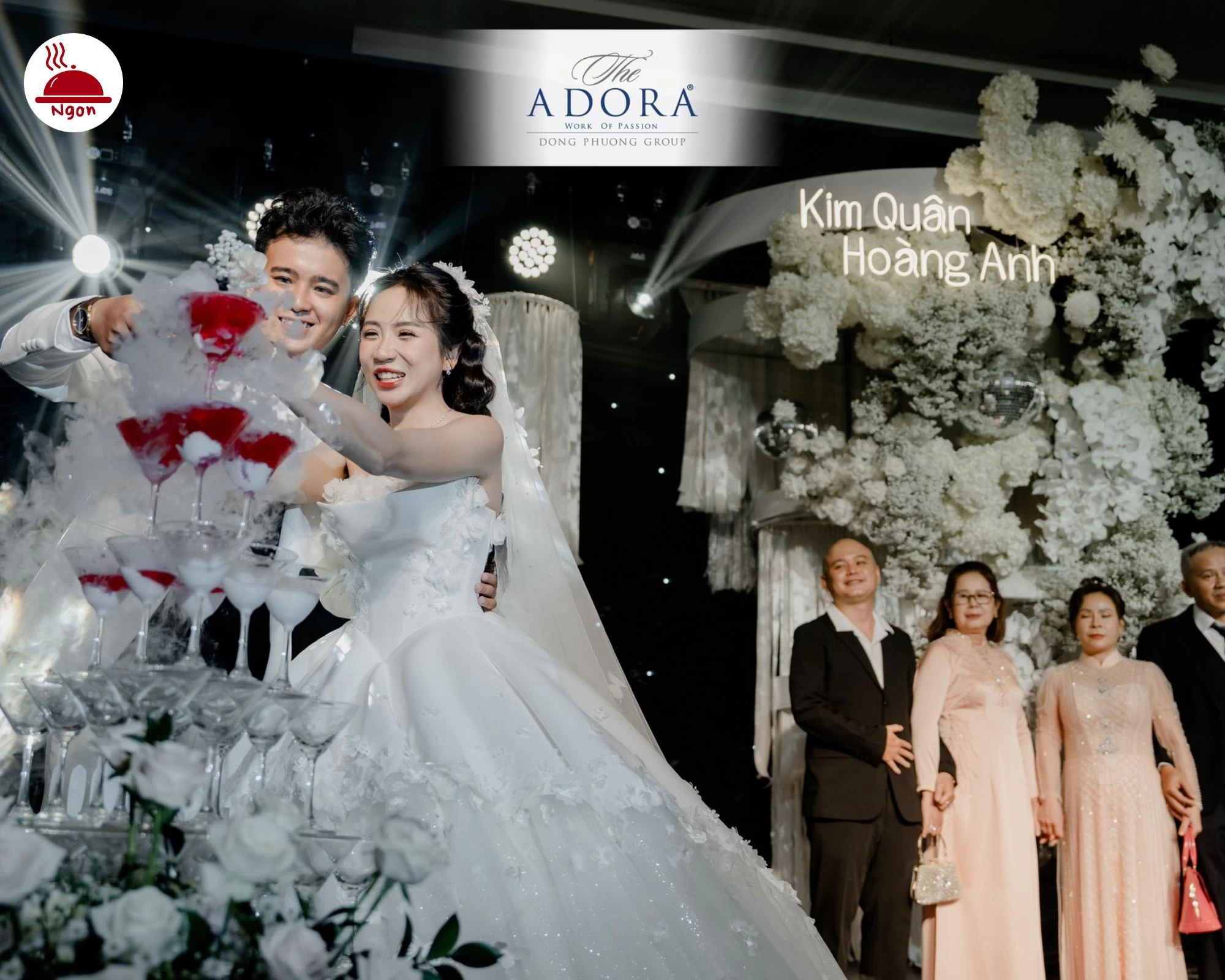 Khoảnh khắc hạnh phúc của cặp đôi tại tiệc cưới The ADORA, với hiệu ứng khói lãng mạn quanh tháp ly và ánh sáng sân khấu ấn tượng