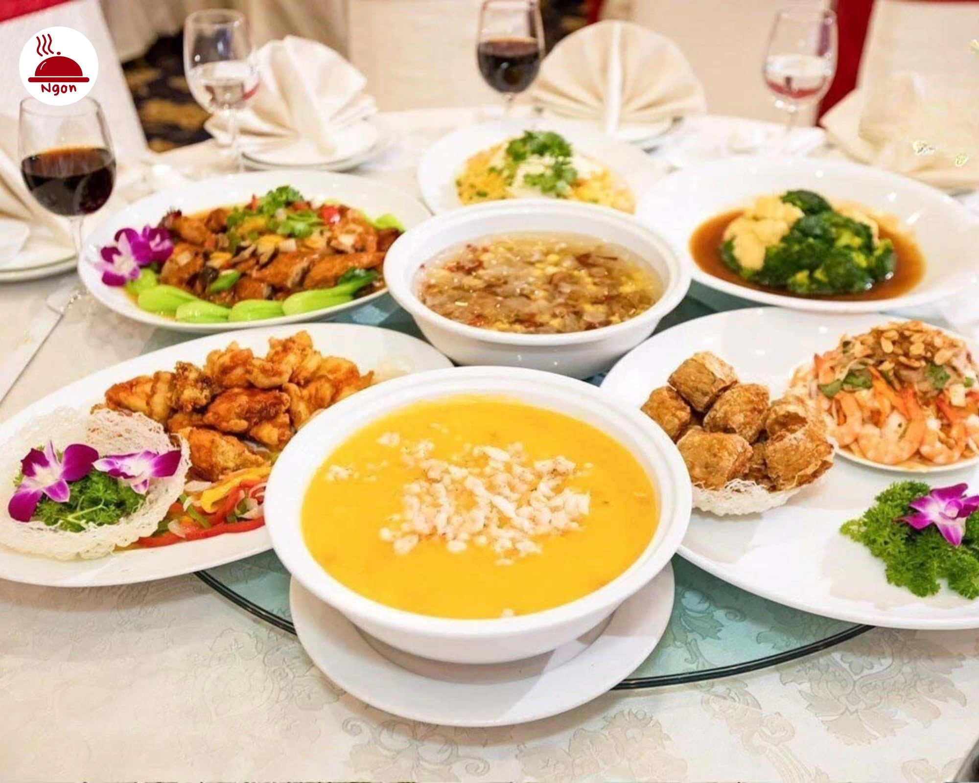 Khung cảnh một bữa tiệc với các món ăn đa dạng được sắp xếp trên bàn tròn, tạo cảm giác sang trọng và đầy đặn