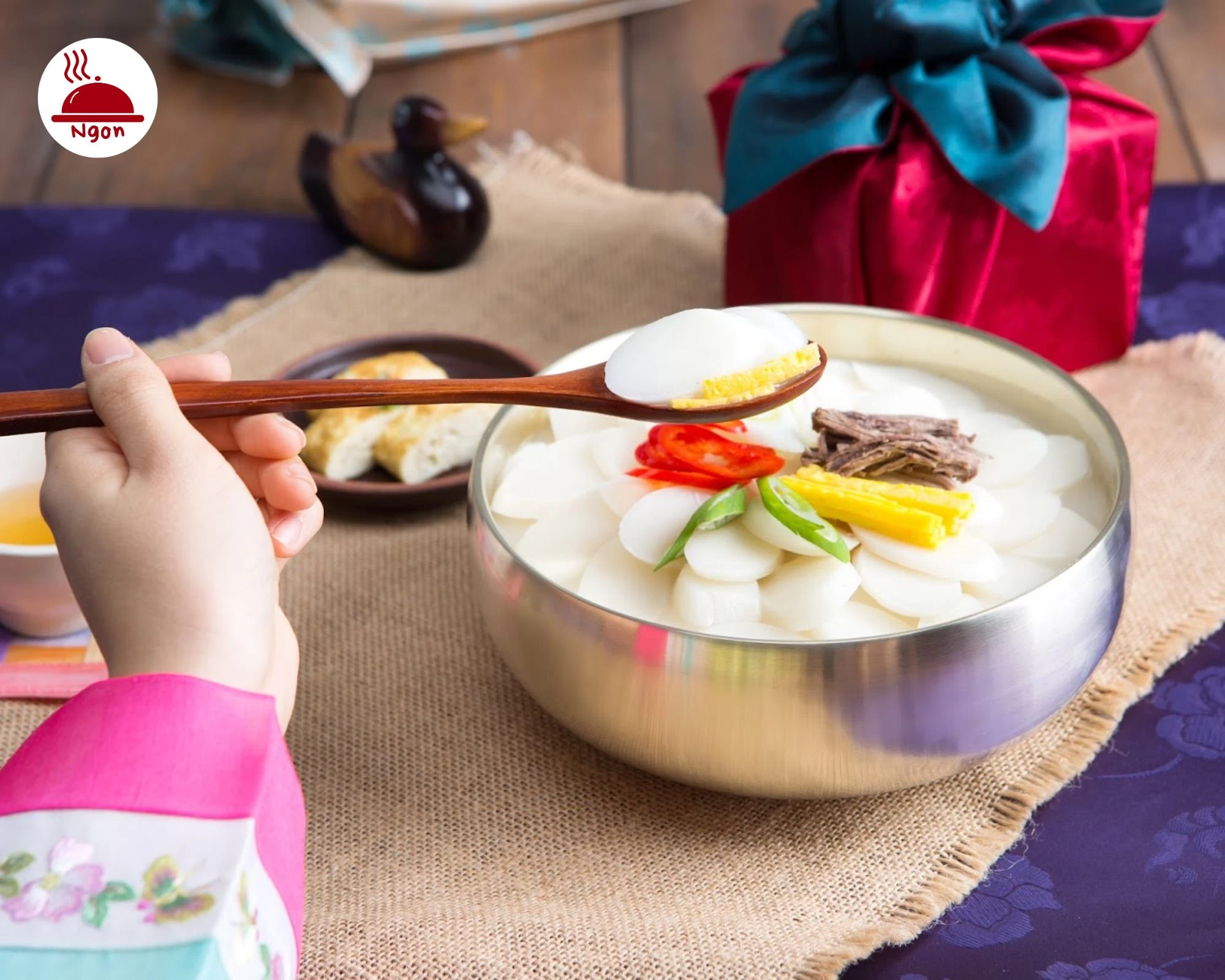 Bánh tteok dẻo mềm trong bát canh ấm nóng