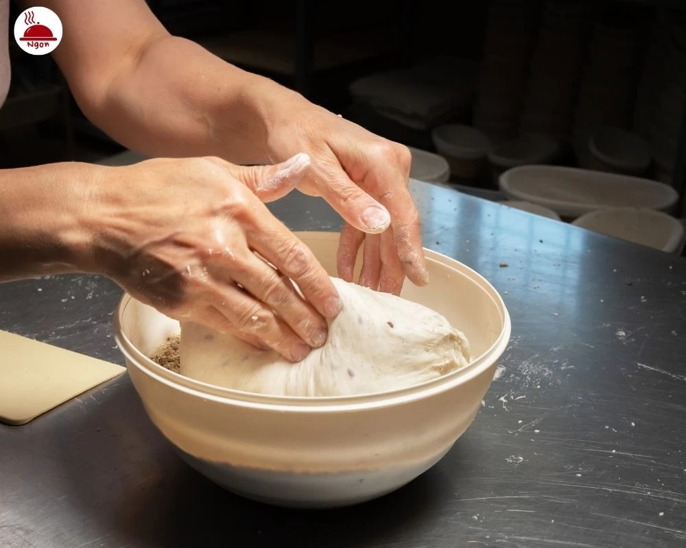 Trộn bột mì làm bánh mandu vào tô