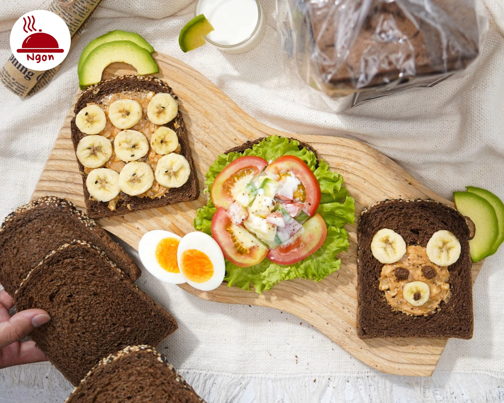 Bàn ăn đầy đủ dinh dưỡng với bánh mì Gạch Đỏ nâu, được ăn kèm với chuối, bơ đậu phộng và salad tôm