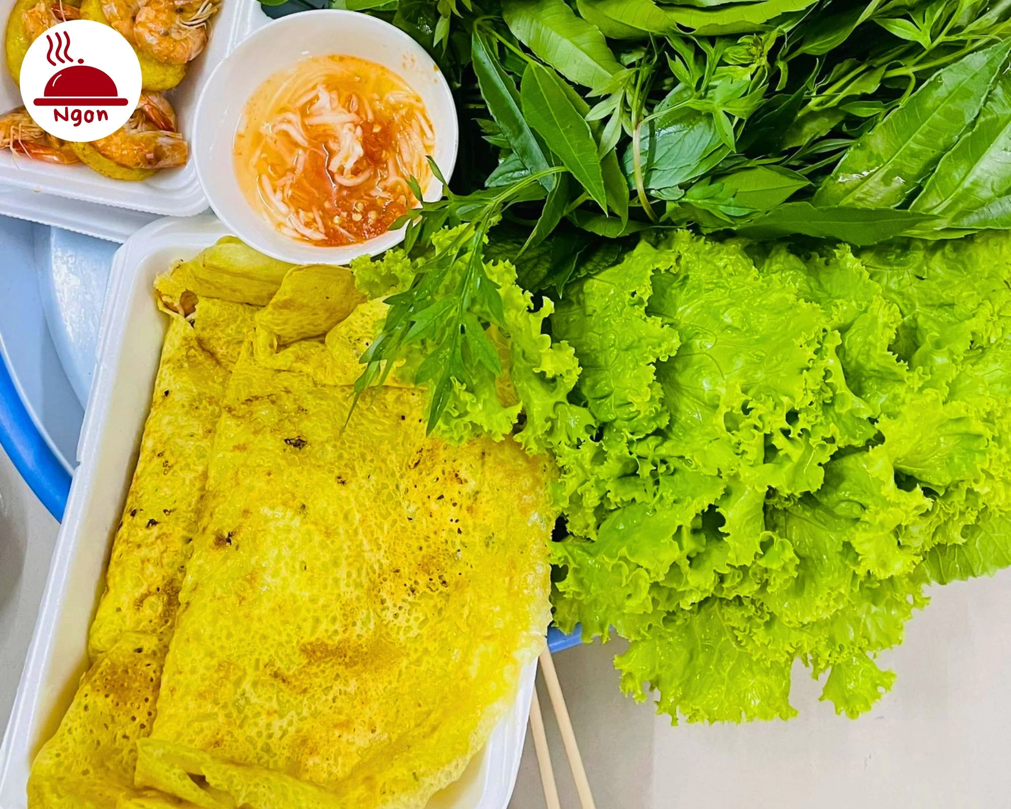 Đĩa bánh xèo vàng ươm, giòn rụm, ăn kèm với xà lách, rau thơm và nước chấm, thể hiện thành quả của cách làm bánh xèo
