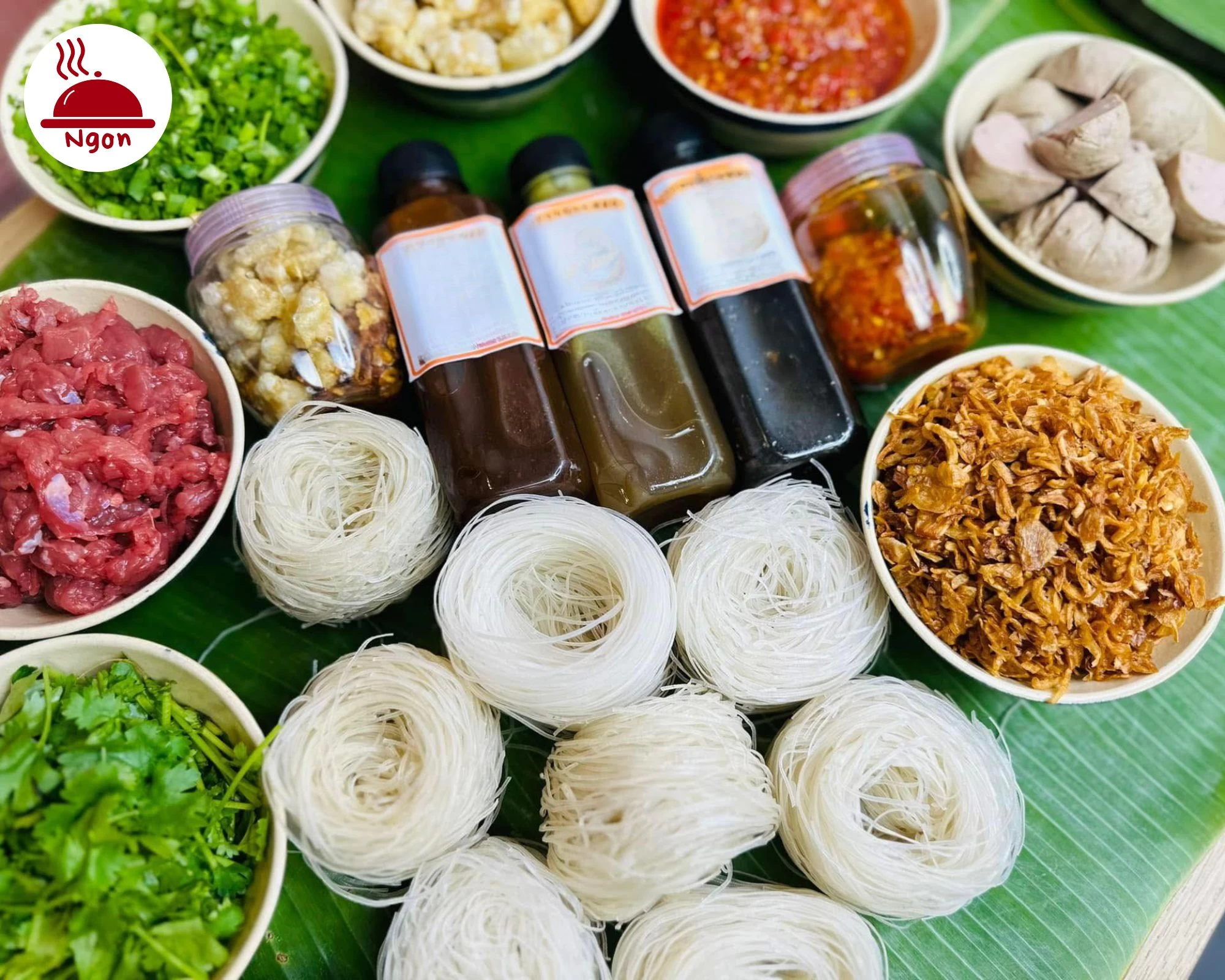 Sợi phở khô, thịt bò tươi, nước sốt đặc trưng, và các loại gia vị phụ trợ cho món Phở Khô Gia Lai