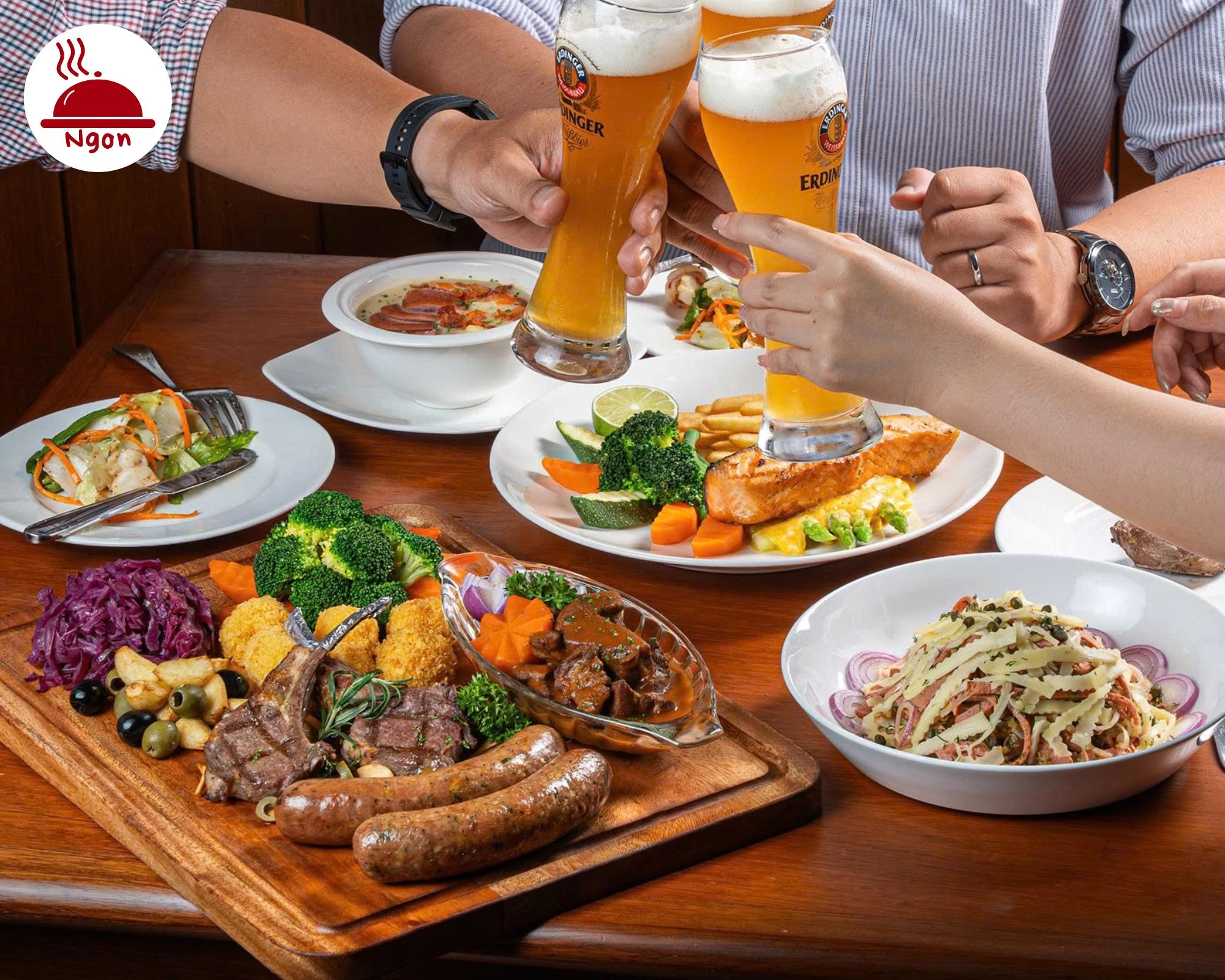 Bàn ăn đầy đủ các món xúc xích, sườn cừu và salad tại Gartenstadt Restaurant