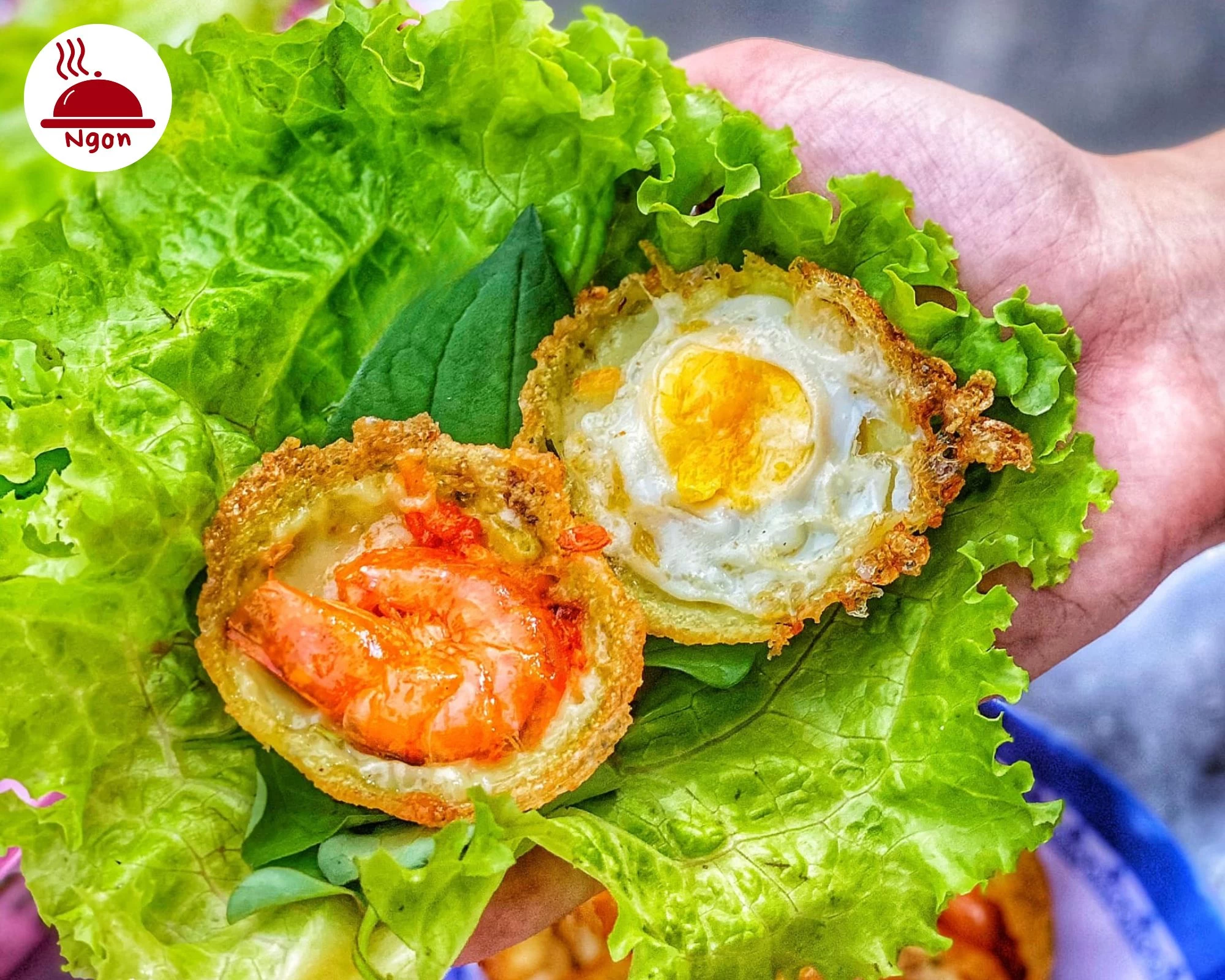 Hai chiếc bánh khọt với lớp vỏ vàng rụm, một nhân tôm và một nhân trứng, minh họa cho việc sử dụng trứng gà trong cách làm bánh khọt giòn lâu
