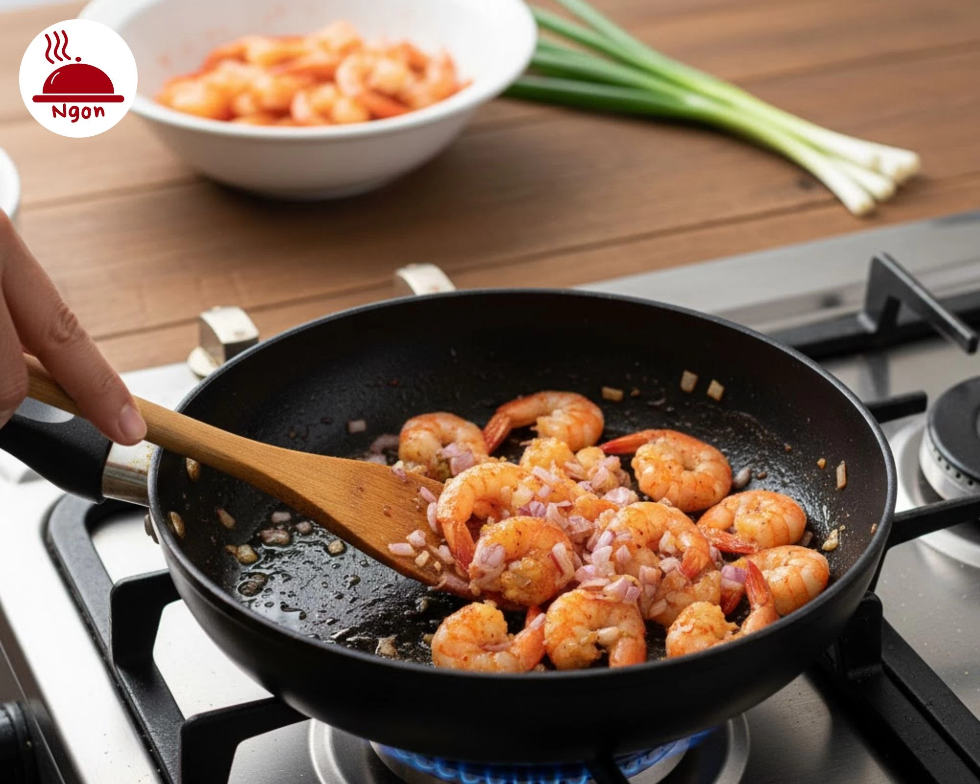 Xào nhân tôm đã ướp cùng hành tím băm trên chảo nóng, là bước quan trọng trong cách làm bánh khọt giòn